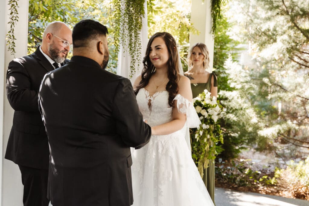 Bride laughing with groom during an intimate forest ceremony, capturing a candid and emotional fairytale wedding moment