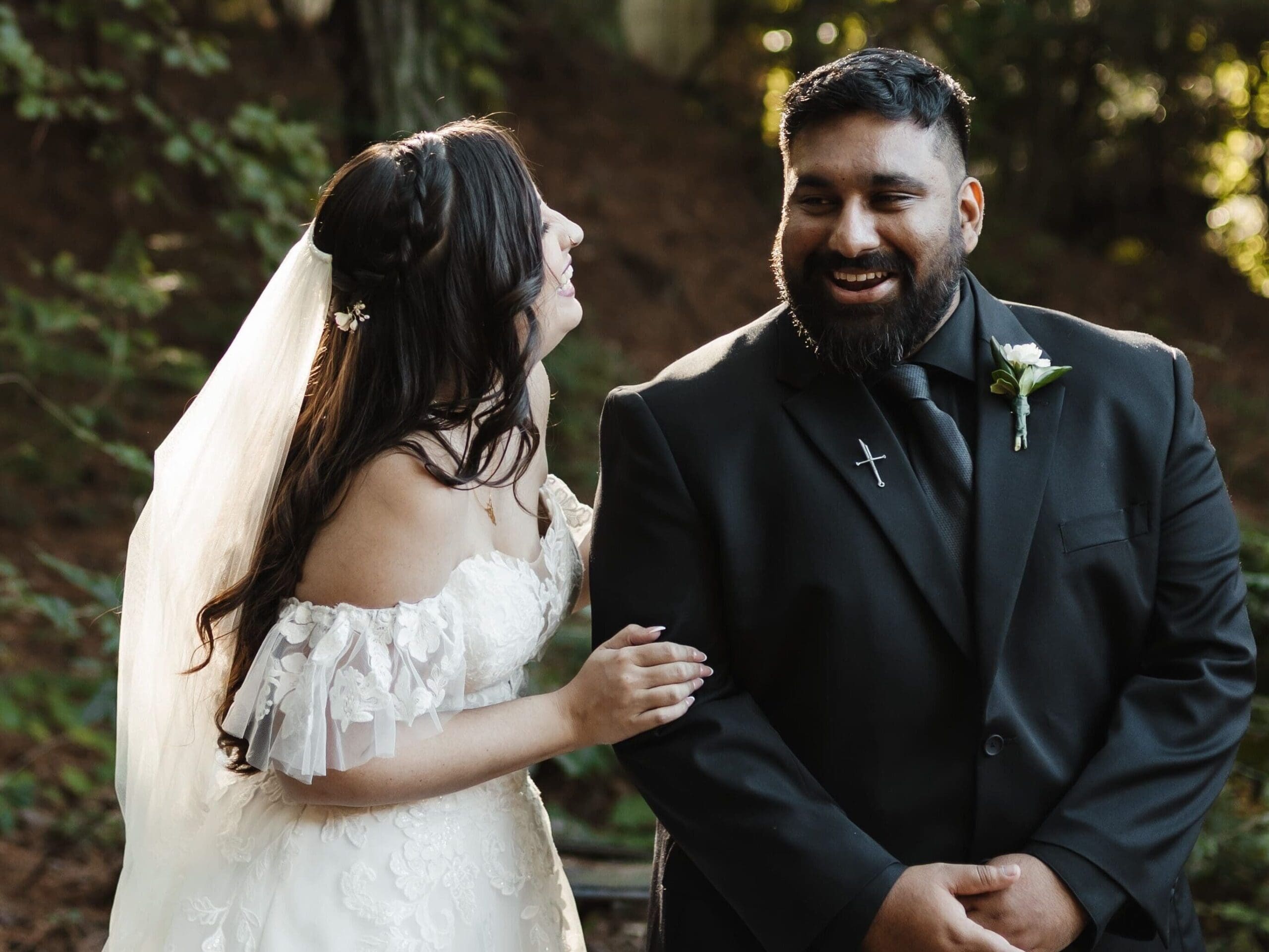 Bride laughing with groom during a woodsy fairytale Georgia wedding, captured in soft golden forest light