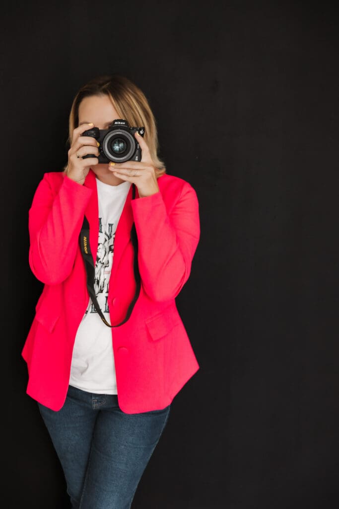 Photographer photographing through the camera, framed against a clean black background