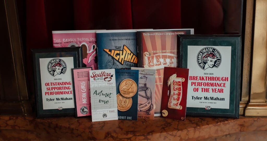 Flat lay of theater programs, playbills, and performance awards showcasing a drama major’s senior achievements