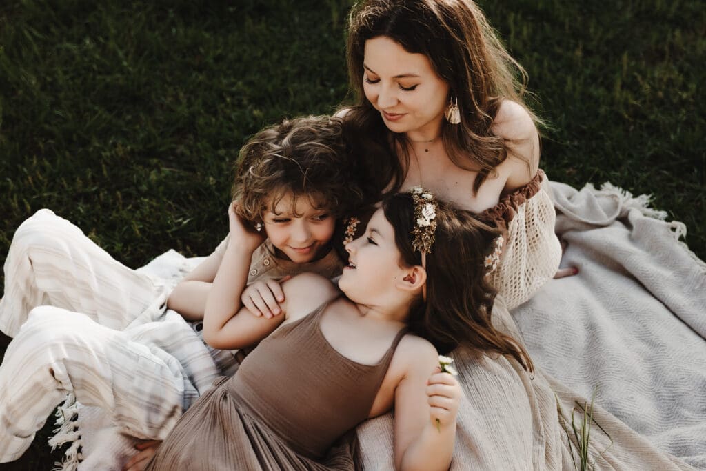 Mother relaxing on a blanket with her son and daughter during a Cleveland Georgia motherhood photography session at Powell Barn.
